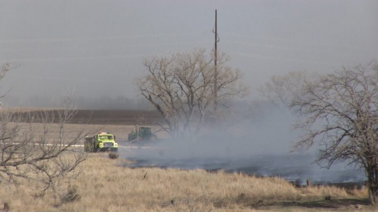 Ellis Co. Rural Fire puts down water on a fire near Catherine as the ground to the east is disked by a tractor to form a fire break.